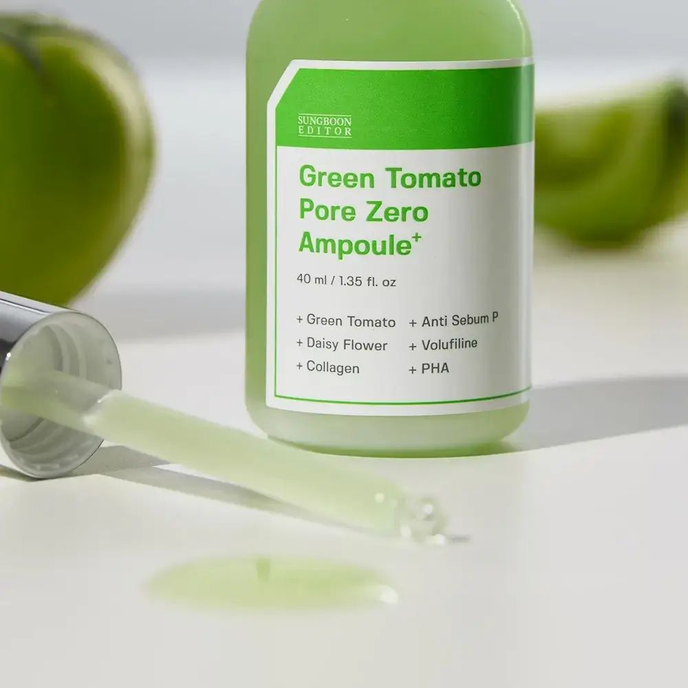 Fiala verde con contagocce e liquido. Etichetta del prodotto visibile. Testo: Green Tomato Pore Zero Ampoule+.