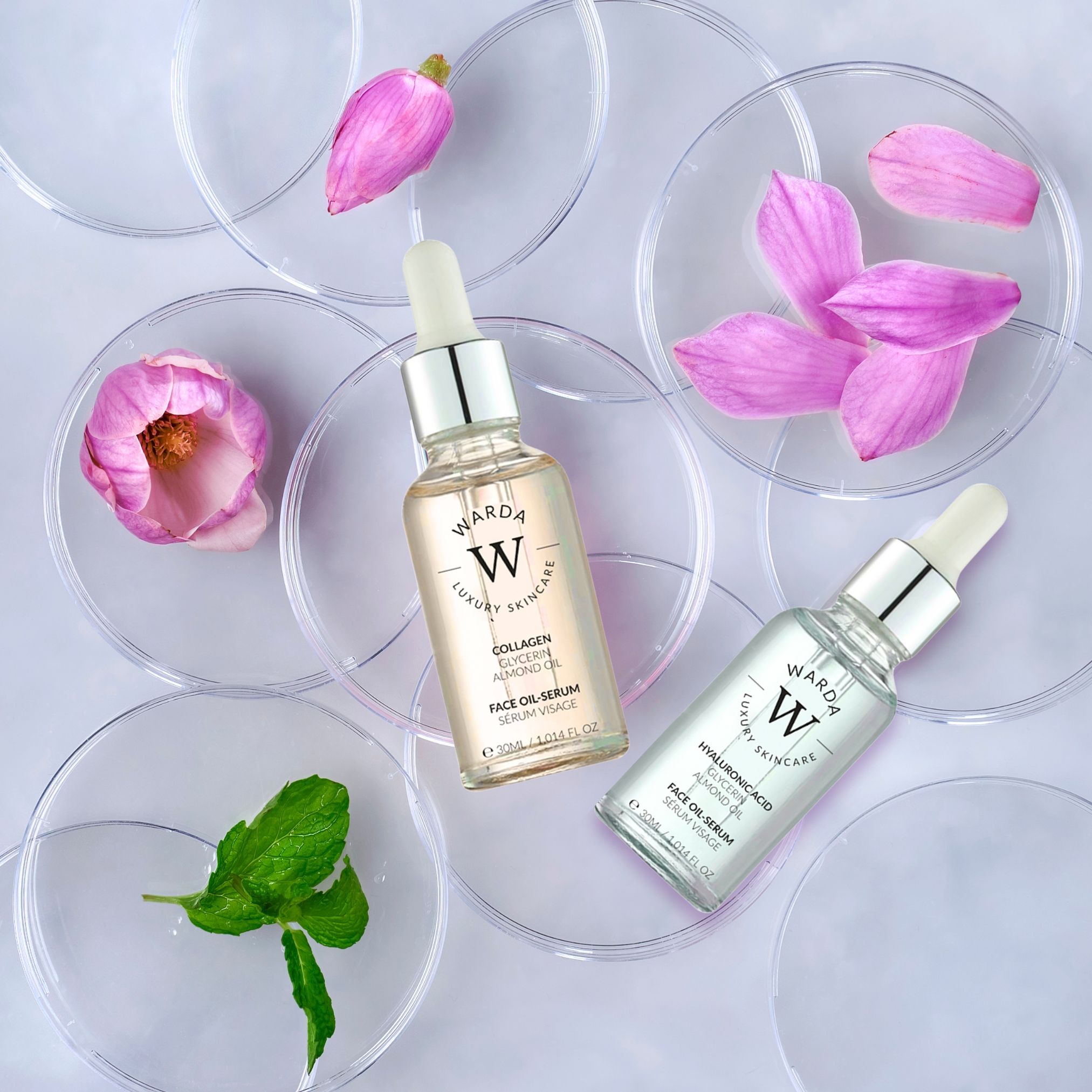 Due flaconi di siero viso Warda. Uno contiene collagene, glicerina e olio di mandorle. L'altro contiene acido ialuronico, glicerina e olio di mandorle. Su sottobicchieri trasparenti.