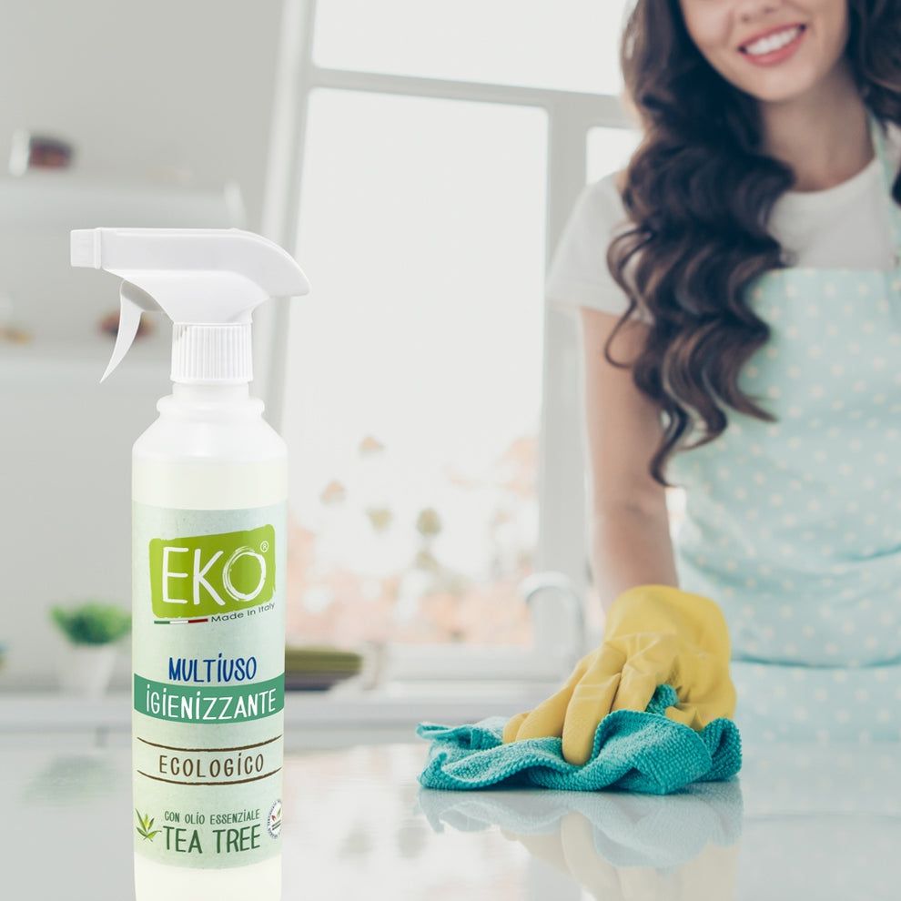 Una donna pulisce una superficie con uno spray detergente EKO.