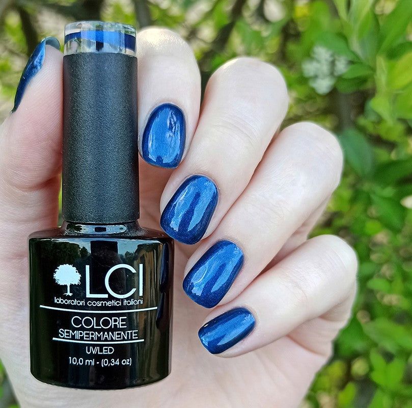 Flacone di smalto e unghie smaltate di blu. Scritta: LCI, Colore Semipermanente, UVLED 10,0 ml.