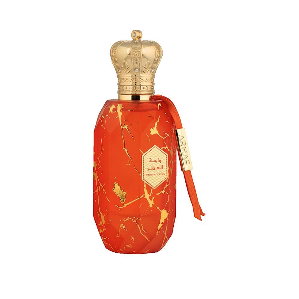 Flacone di profumo con corona dorata e motivo marmorizzato arancione. Nastro rosso con nome del marchio. Caratteri arabi.