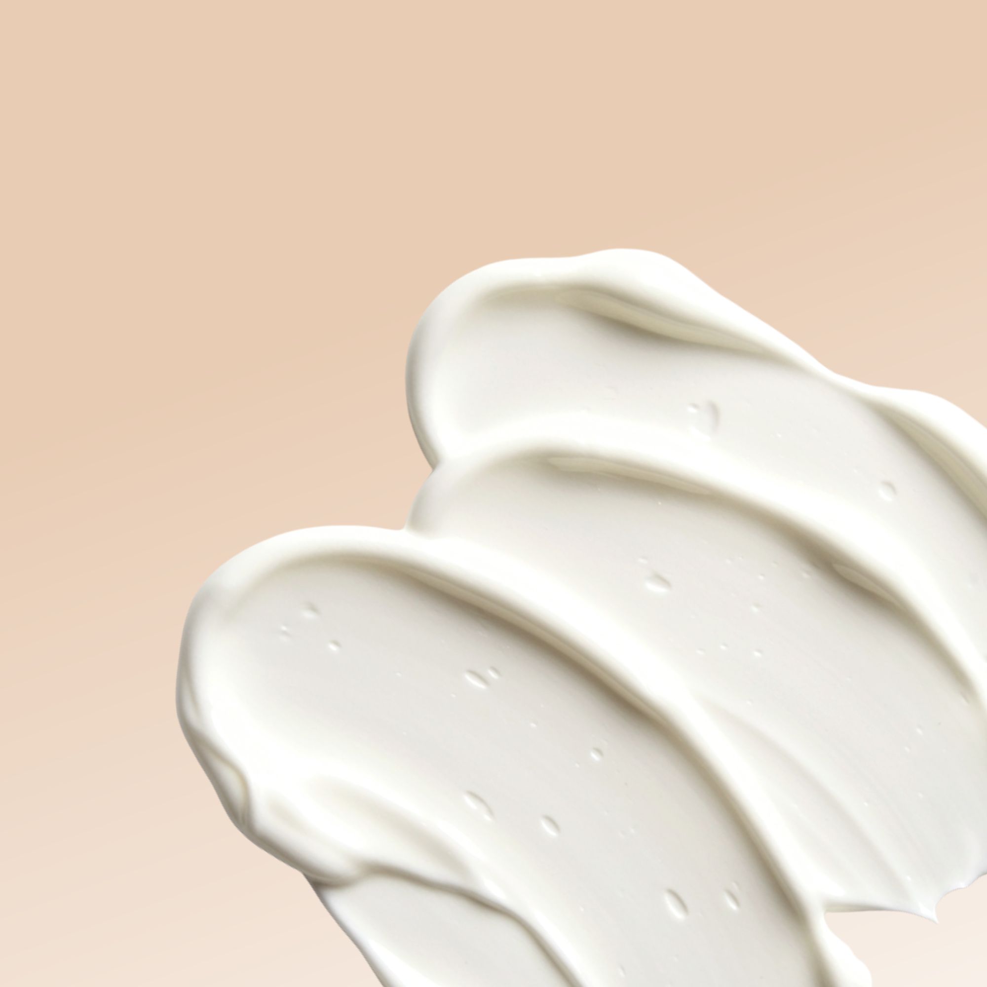 Primo piano di tre strisce di crema color crema su sfondo beige.