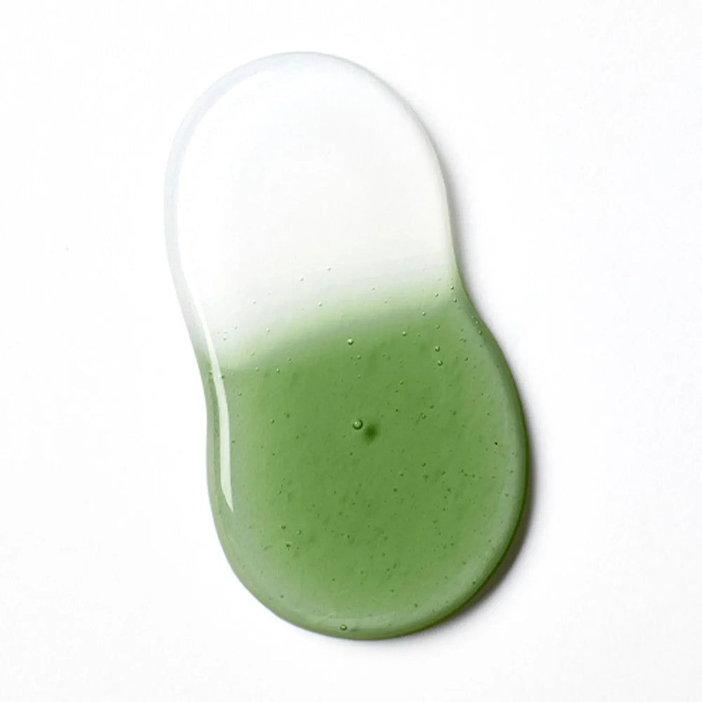 Goccia di olio detergente con sfumatura dal trasparente al verde, su sfondo bianco.