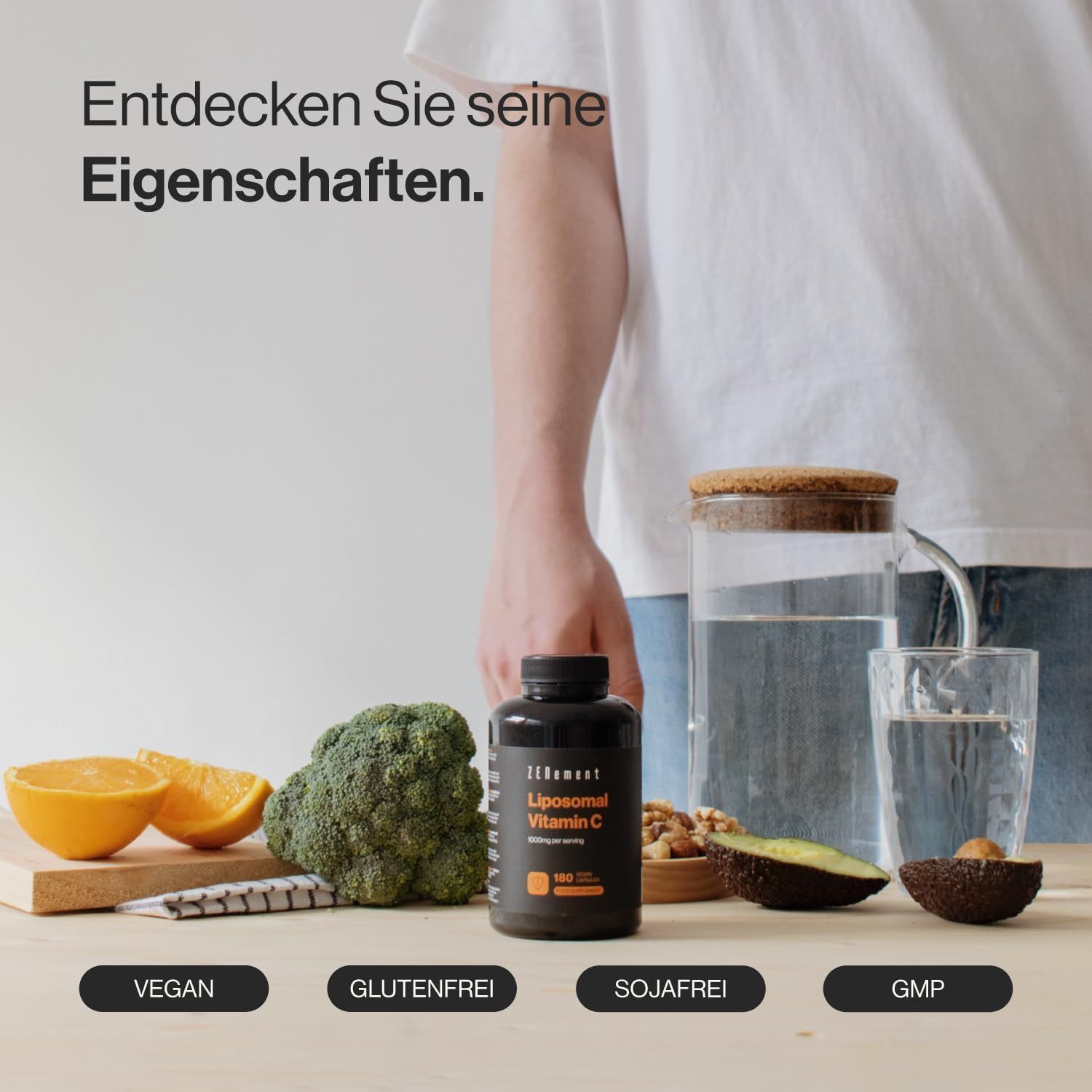 Flacone nero di Zenement Liposomales Vitamina C. Frutta, verdura e acqua accanto. Vegano, senza glutine, senza soia, GMP.