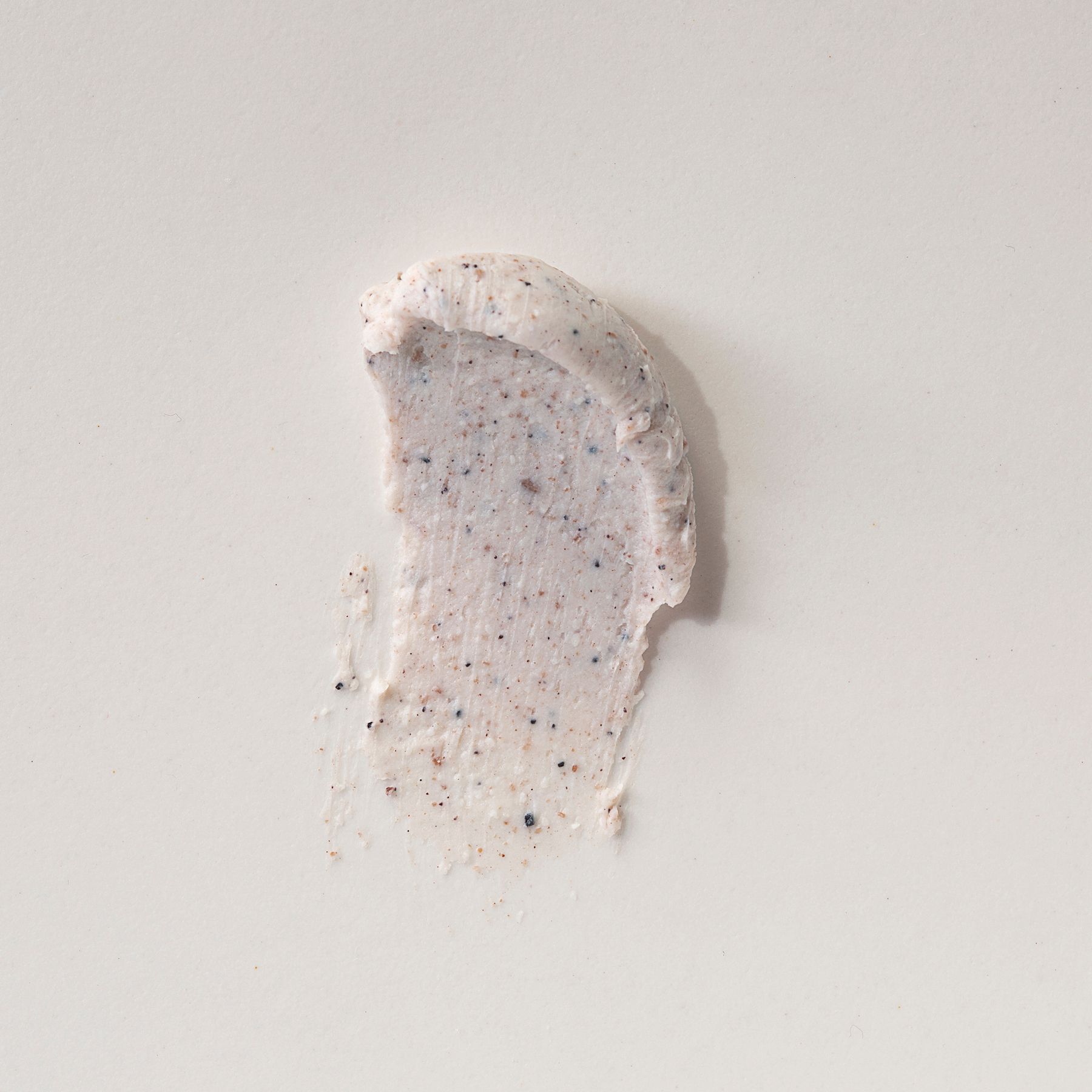 Un campione di Alkemy Karité Butter Scrub esfoliante corpo su sfondo chiaro.