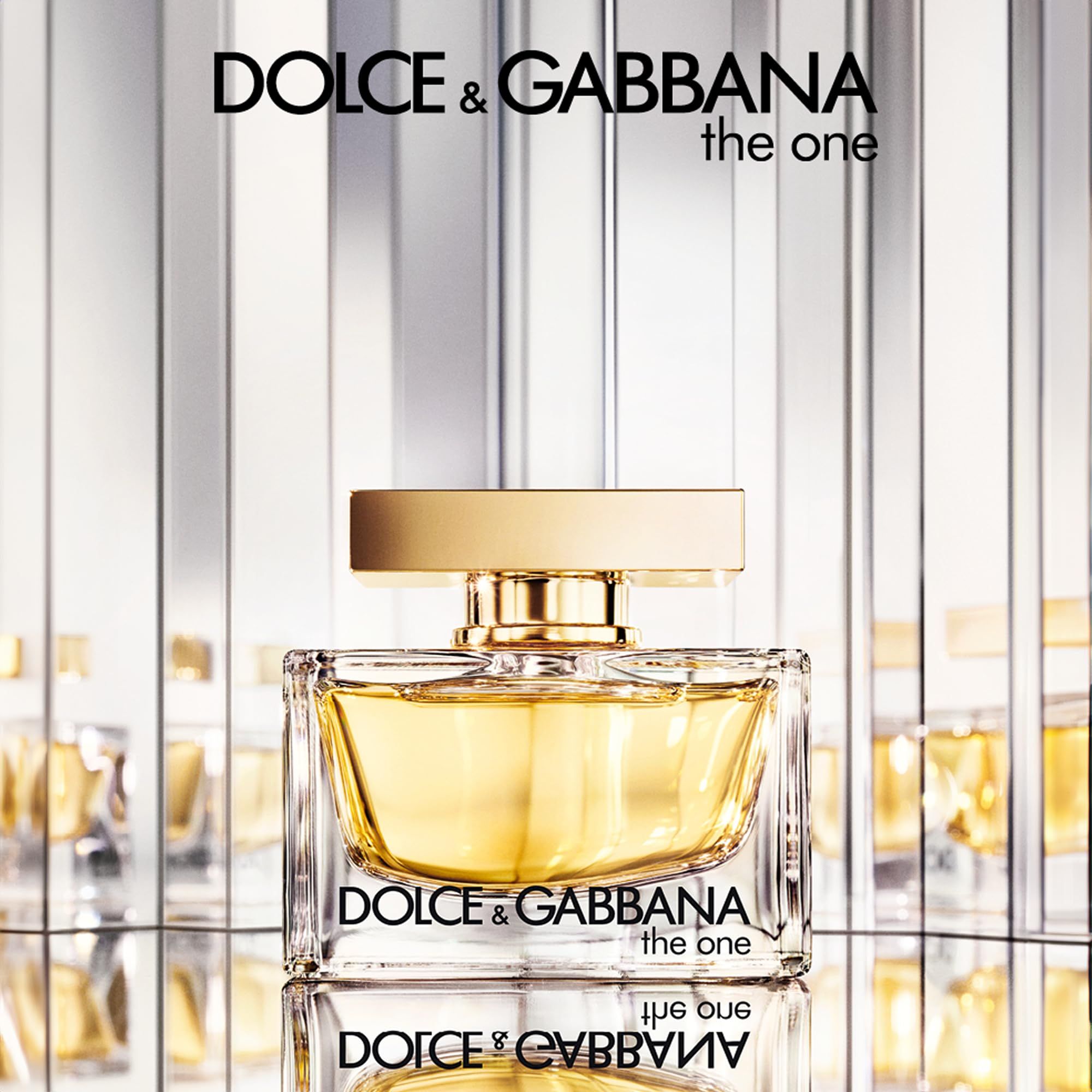 Flacone in vetro con tappo dorato, davanti a uno specchio. Scritta: Dolce & Gabbana, the one. Riflesso.