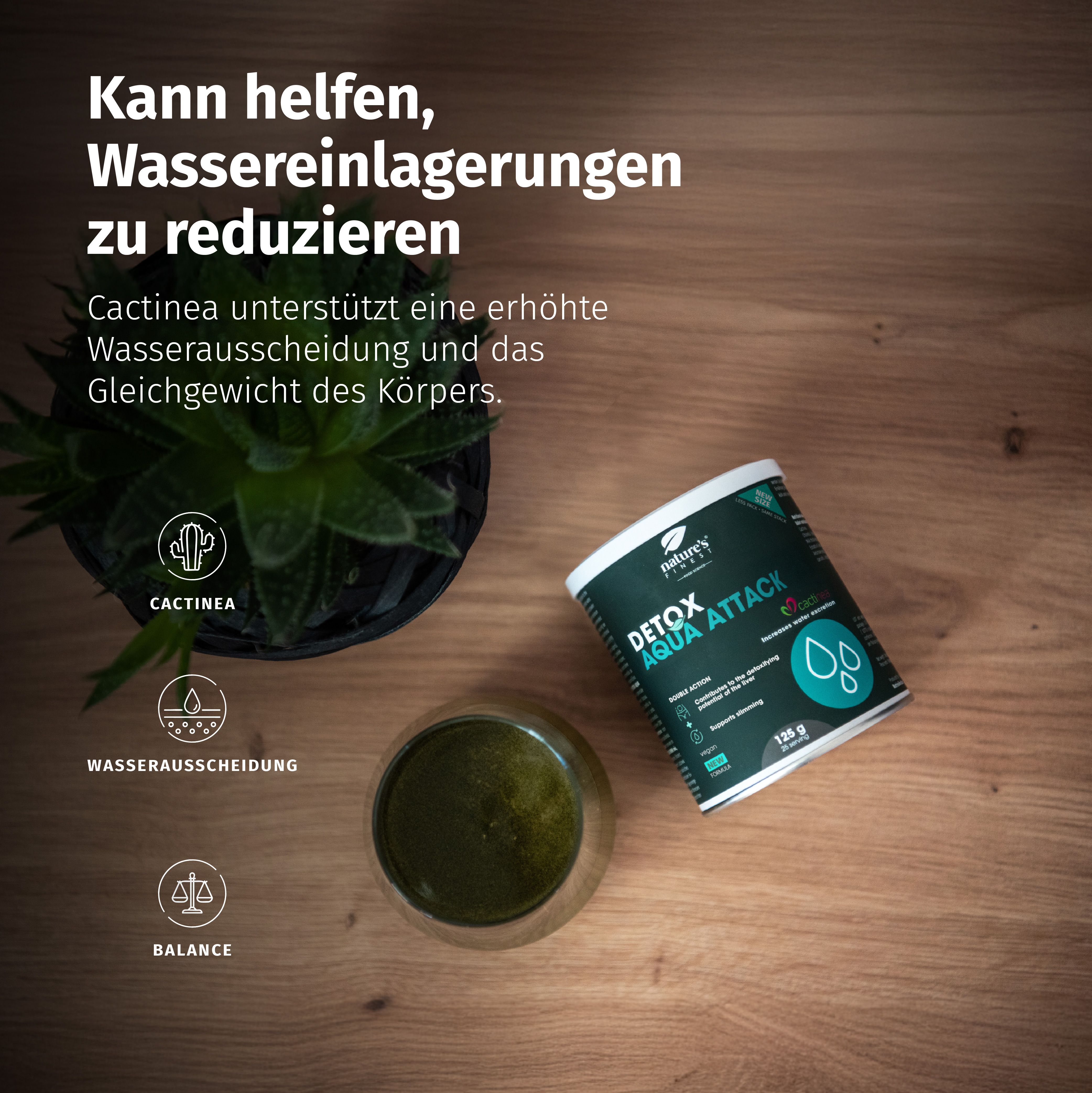 Barattolo Detox Aqua Attack accanto a un bicchiere di bevanda verde e una pianta.