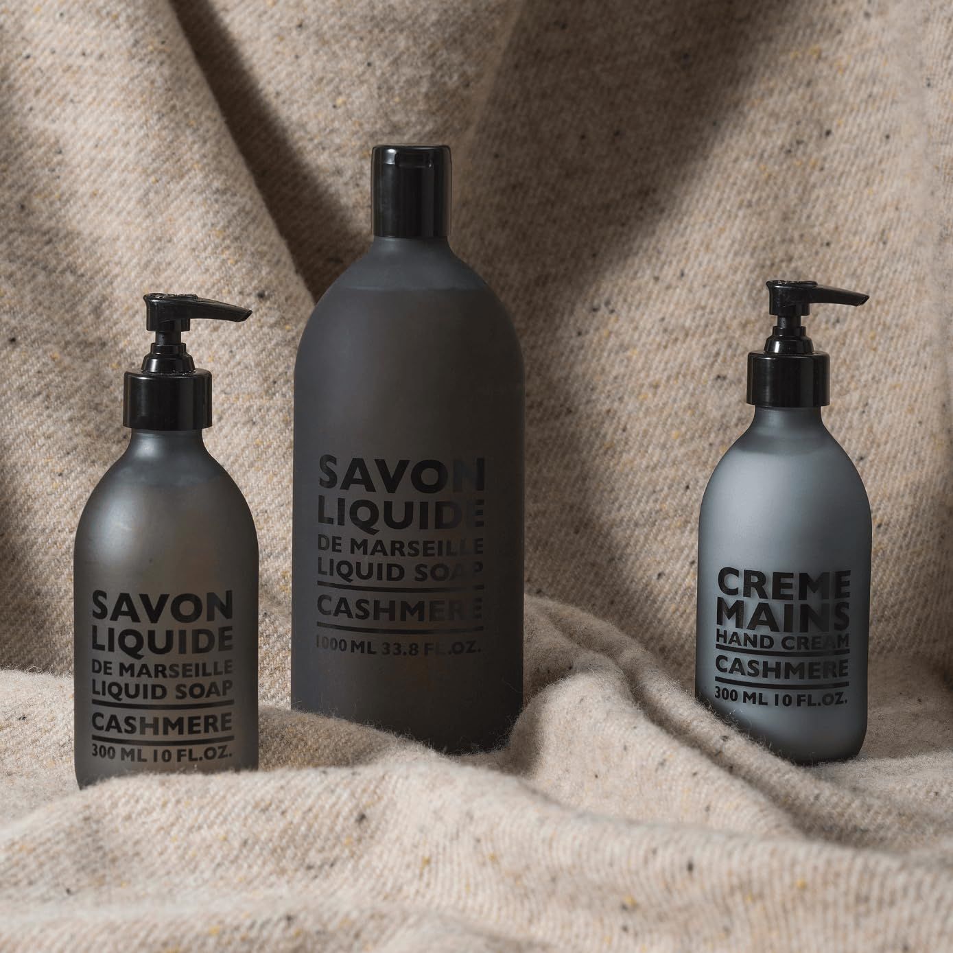 Tre flaconi: uno grande e due più piccoli con pompa. Scritta: SAVON LIQUIDE e CRÈME MAINS CASHMERE.