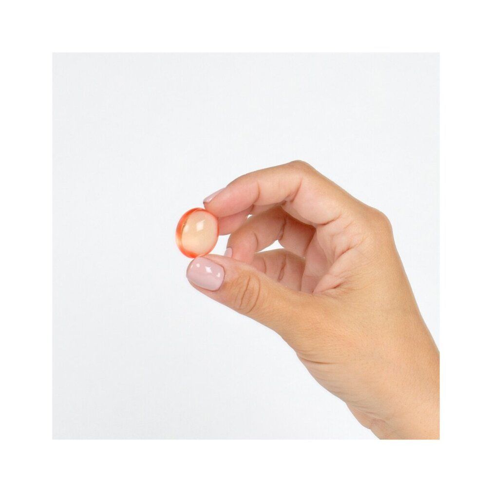 Mano che tiene una sfera rotonda e trasparente. Pelle chiara, unghie smaltate di rosa. Sfondo bianco.