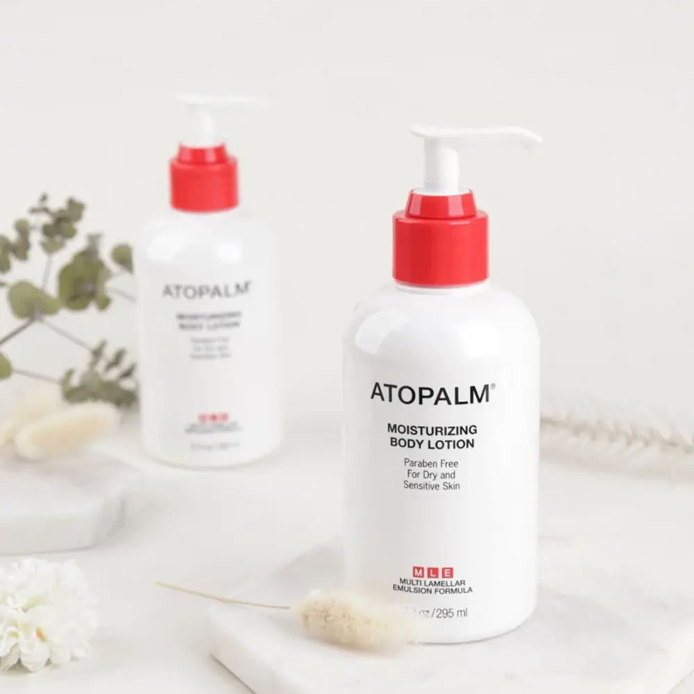 Due flaconi bianchi con erogatore rosso. Scritta: ATOPALM Moisturizing Body Lotion.