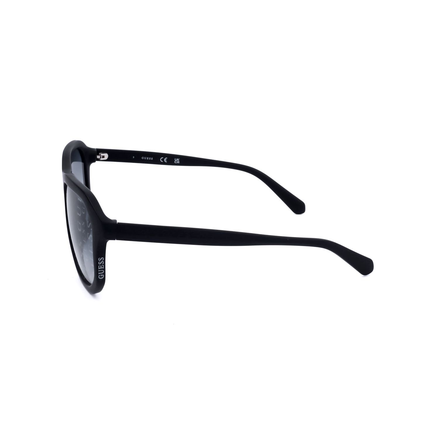 Occhiali da sole Guess neri, vista laterale. Montatura nera, lenti scure. Scritta "GUESS" sul'asta.