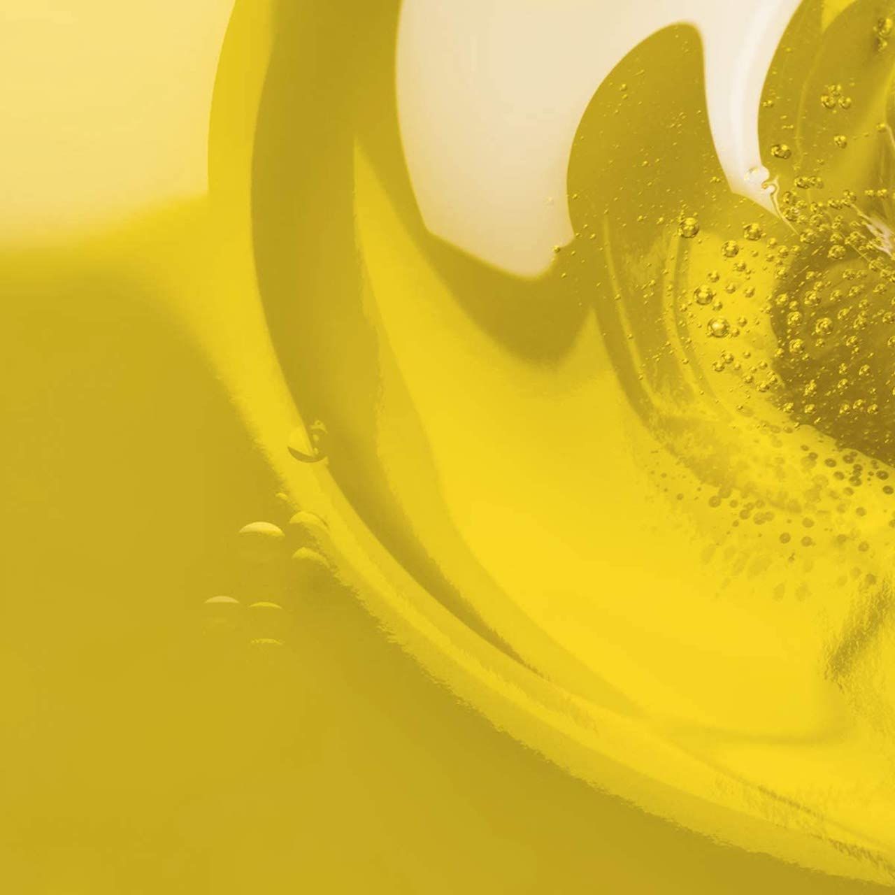Primo piano di olio giallo con bolle. Liquido con vortici e piccole bolle d'aria. Colore giallo chiaro.