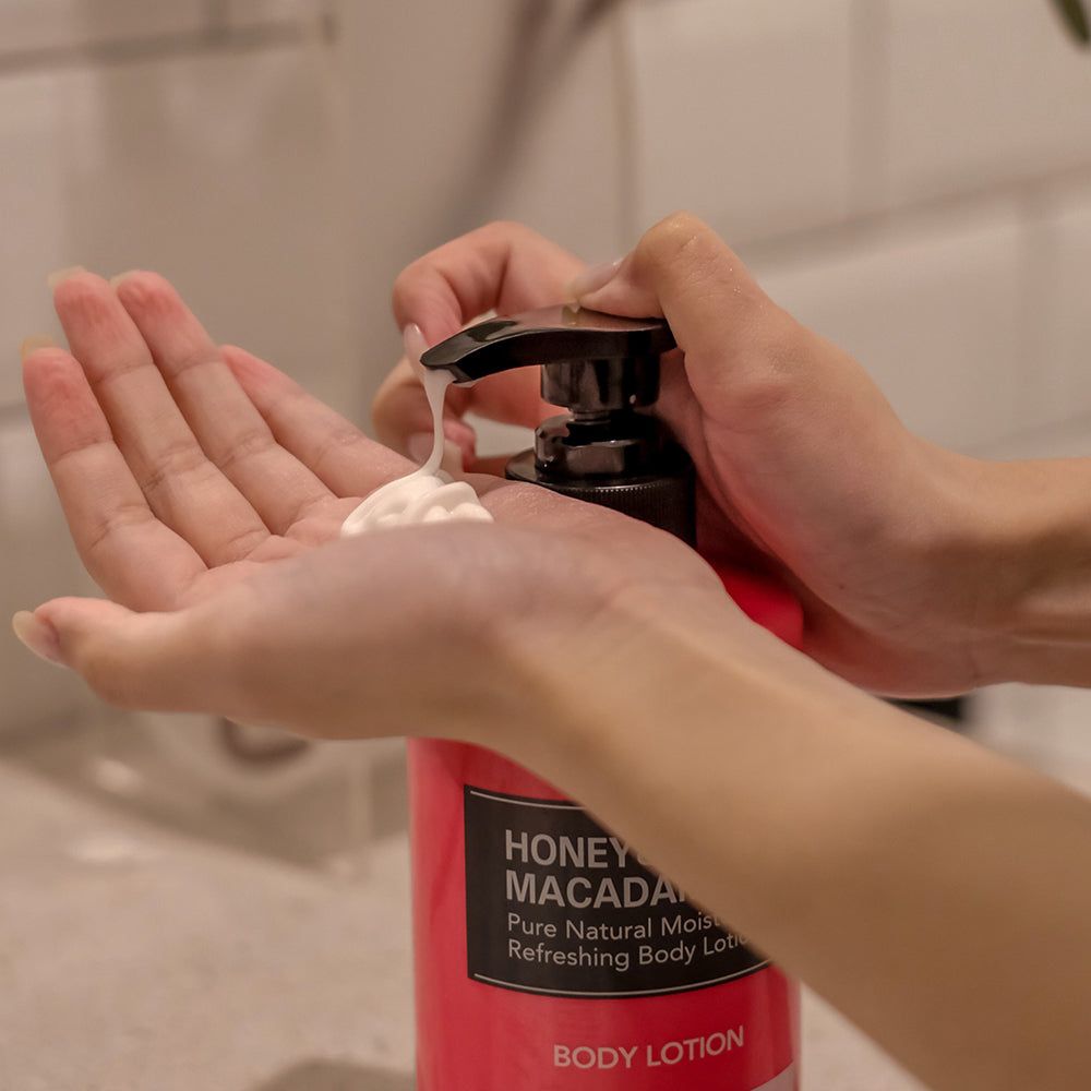 Una mano preme una lozione corpo Kundal nell'altra mano. Erogatore con lozione.