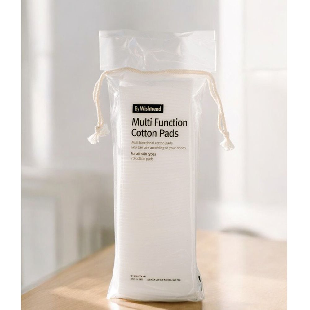 Confezione di dischetti di cotone. Scritta: By Wishtrend Multi Function Cotton Pads. 70 dischetti. Confezione trasparente con cordino. Su tavolo.