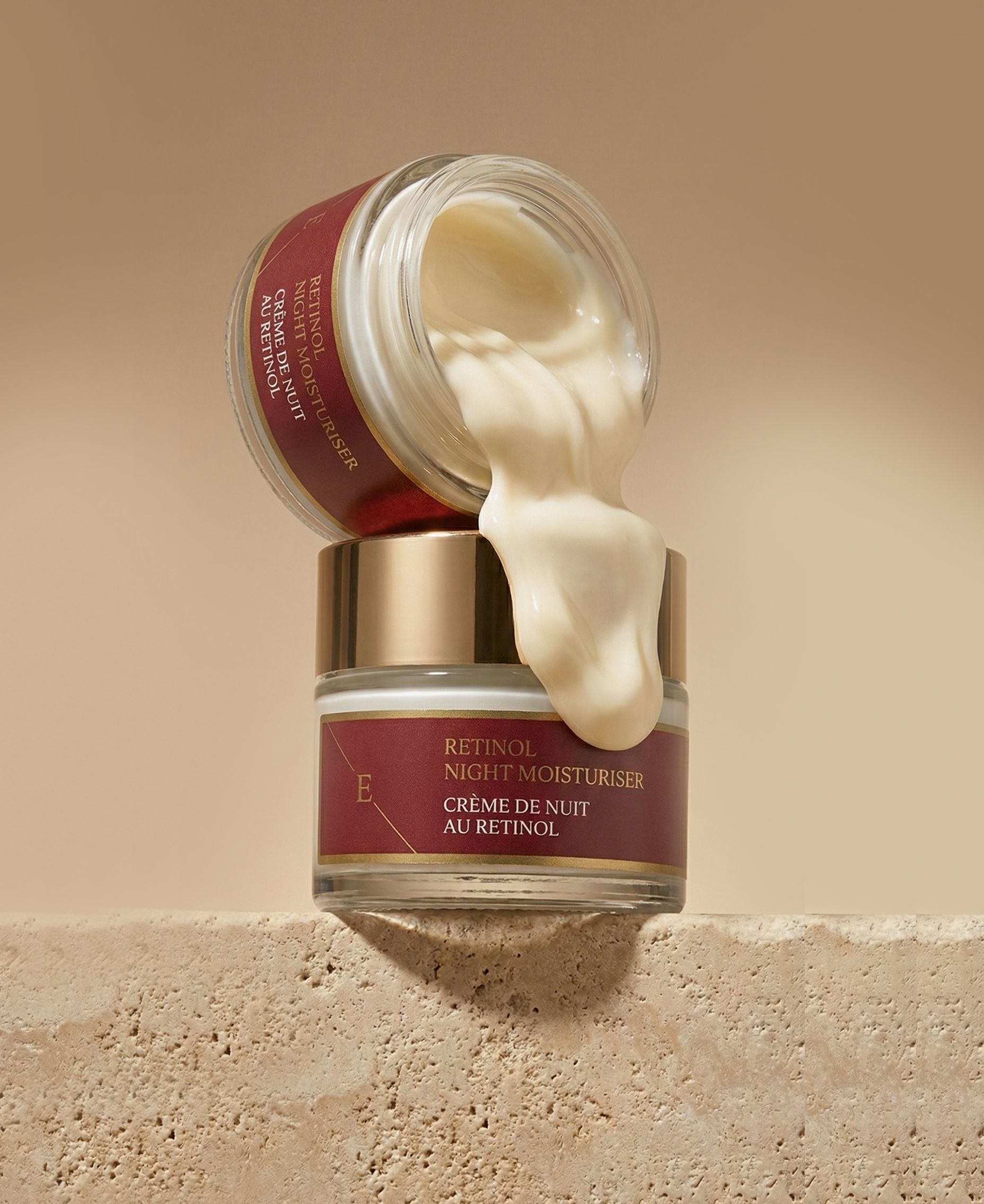 Due vasetti di crema, uno aperto, la crema cola. Testo: Retinol Night Moisturiser, Crème de Nuit au Rétinol.