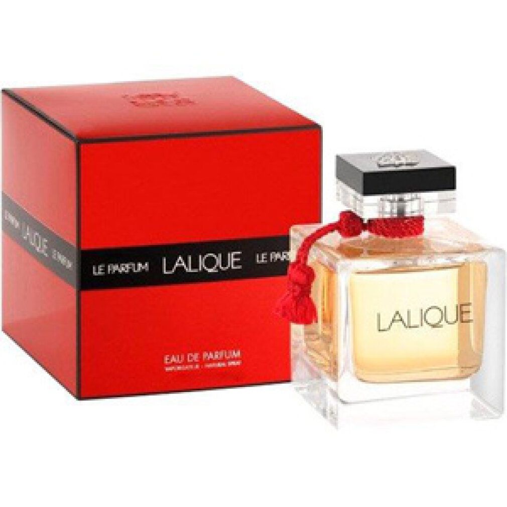 Scatola rossa accanto a flacone in vetro. Flacone con liquido ambrato, tappo nero, nappa rossa. Scritta: LALIQUE LE PARFUM.
