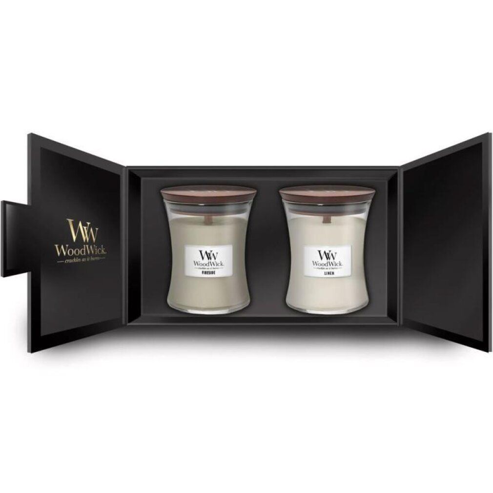 Confezione regalo con due candele. Vasi con coperchi in legno ed etichette. Scritta: WoodWick. Scatola nera aperta.