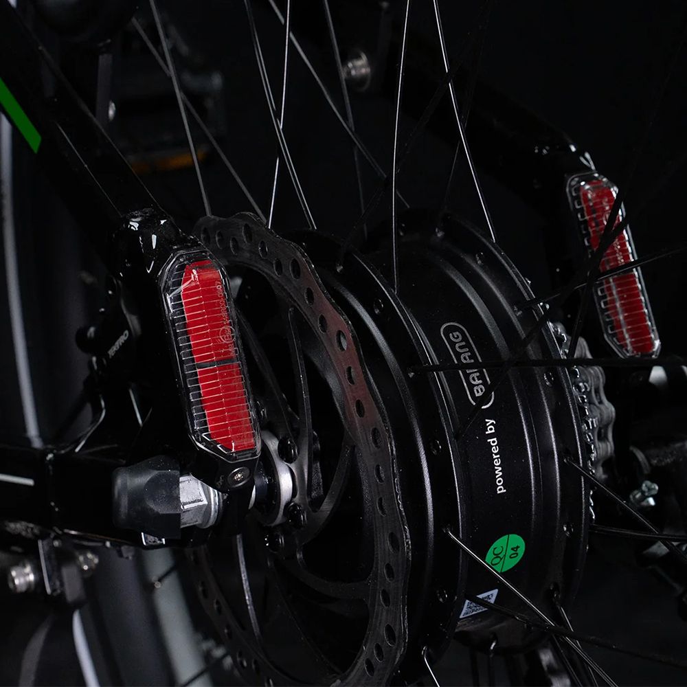 Primo piano del freno posteriore e del motore. Catadiottri rossi e freno a disco. Scritta: Powered by Bafang.