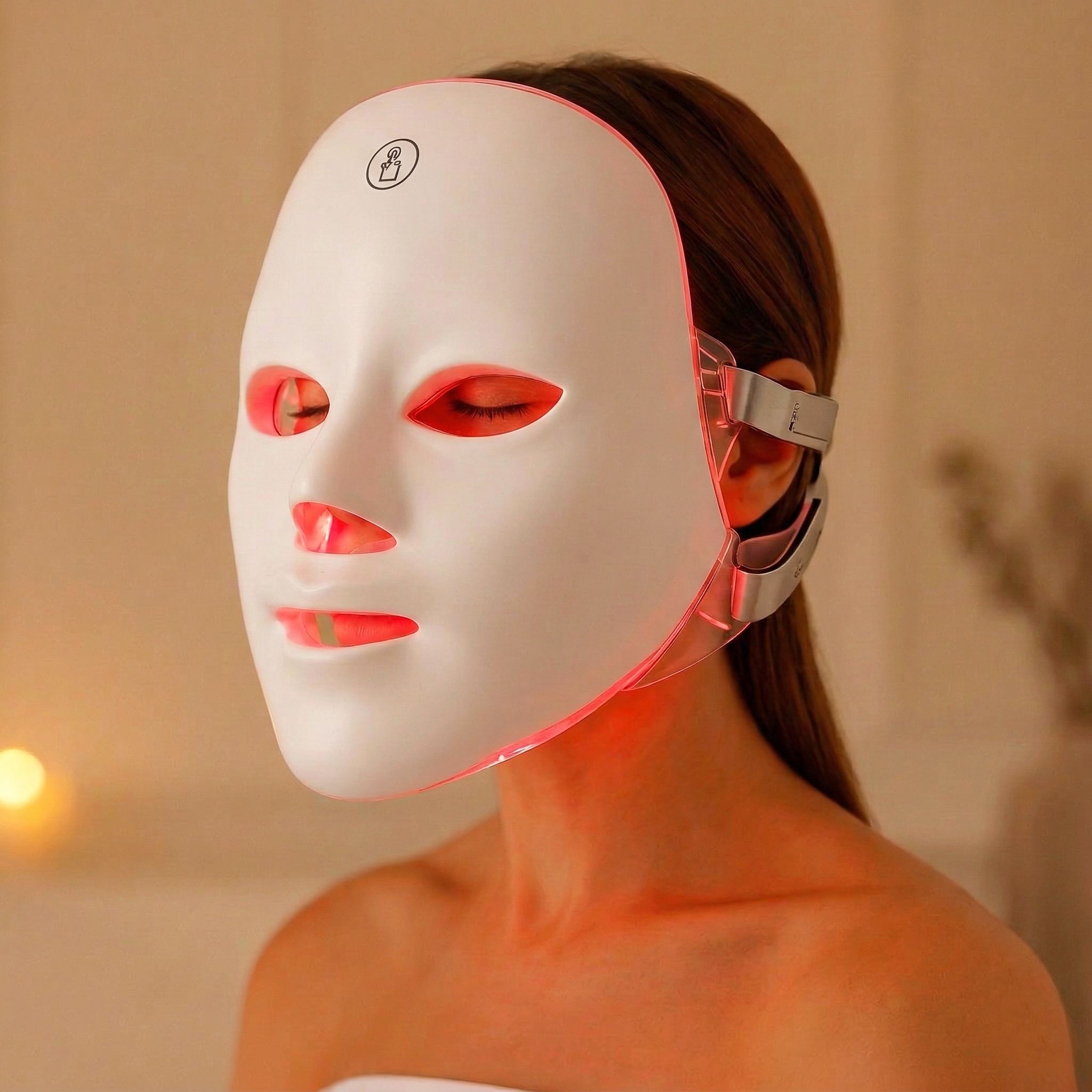 Maschera facciale bianca con luci rosse, indossata da una persona. Supporti laterali visibili.