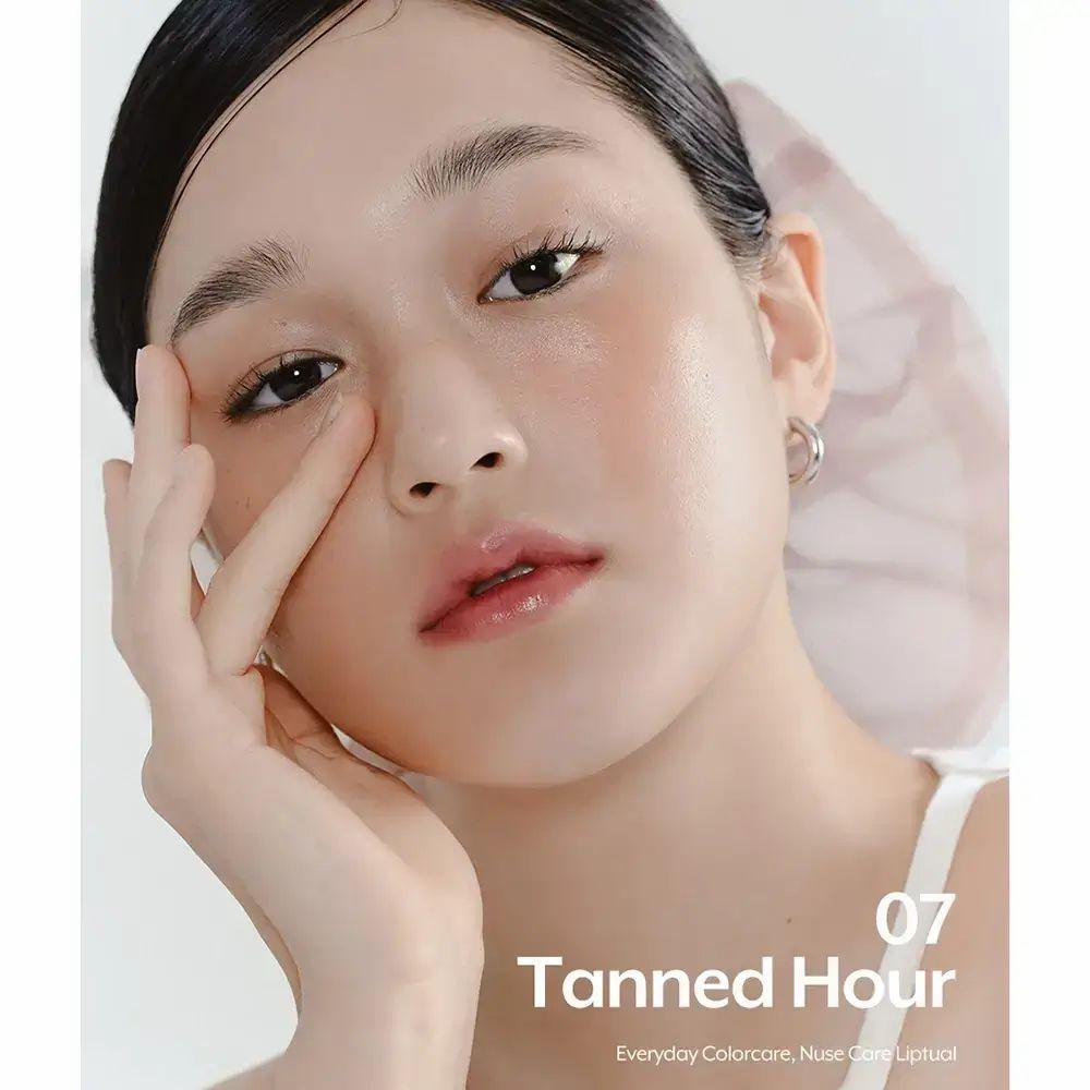 Ritratto di donna con lucidalabbra. Il testo indica "07 Tanned Hour" e il nome del marchio.