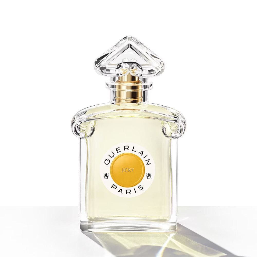 Flacone di profumo con etichetta rotonda. Scritta: GUERLAIN PARIS, JICKY. Flacone trasparente.