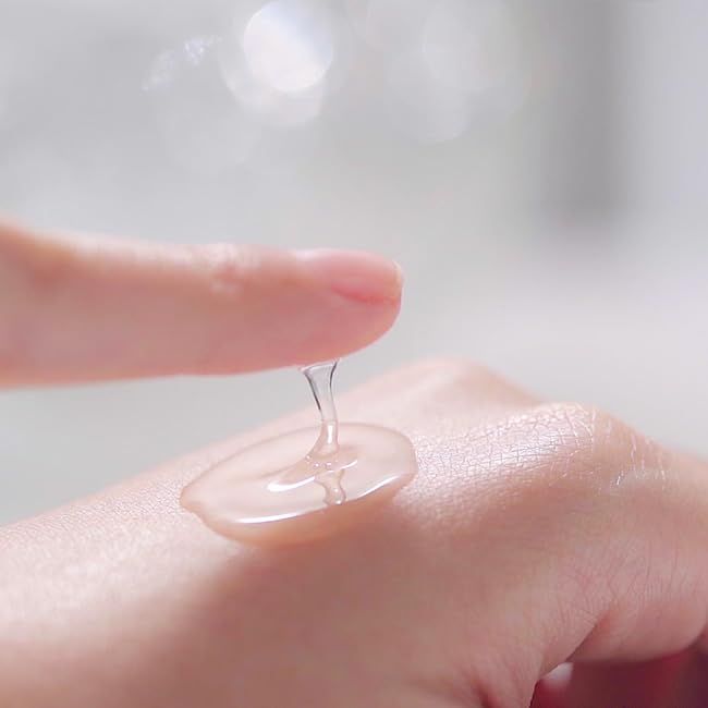 Mano con goccia di gel. Gel su dito e mano. Pelle chiara. Sfondo sfocato.