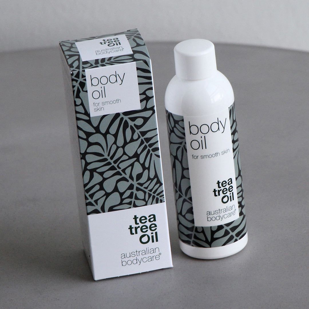 Flacone e confezione Body Oil. Flacone e scatola bianchi con motivi a foglie grigie. Testo: Tea Tree Oil, Australian Bodycare.