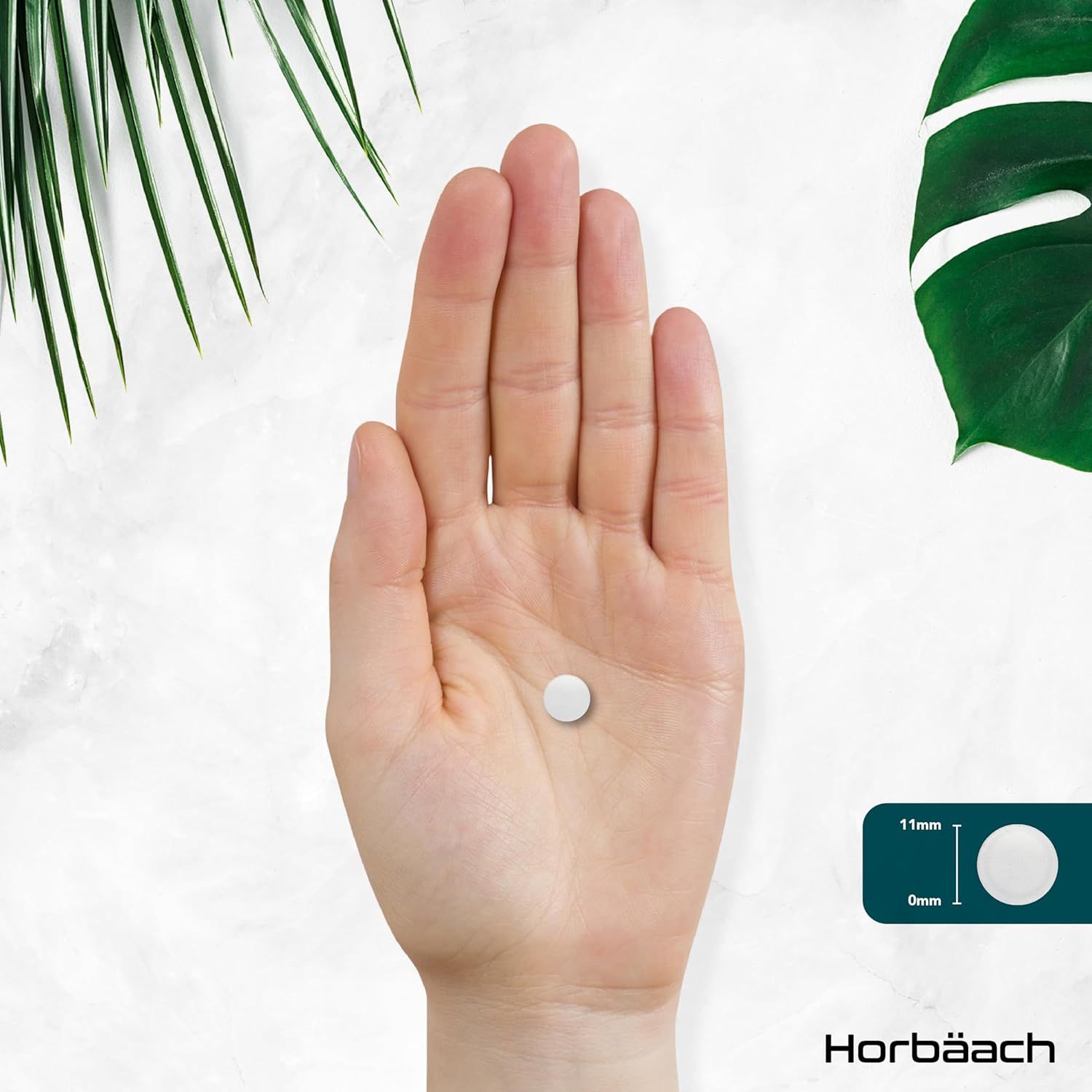 Mano che tiene una compressa di zinco bianca. Dimensioni: 11mm x 6mm. Logo Horbaach.