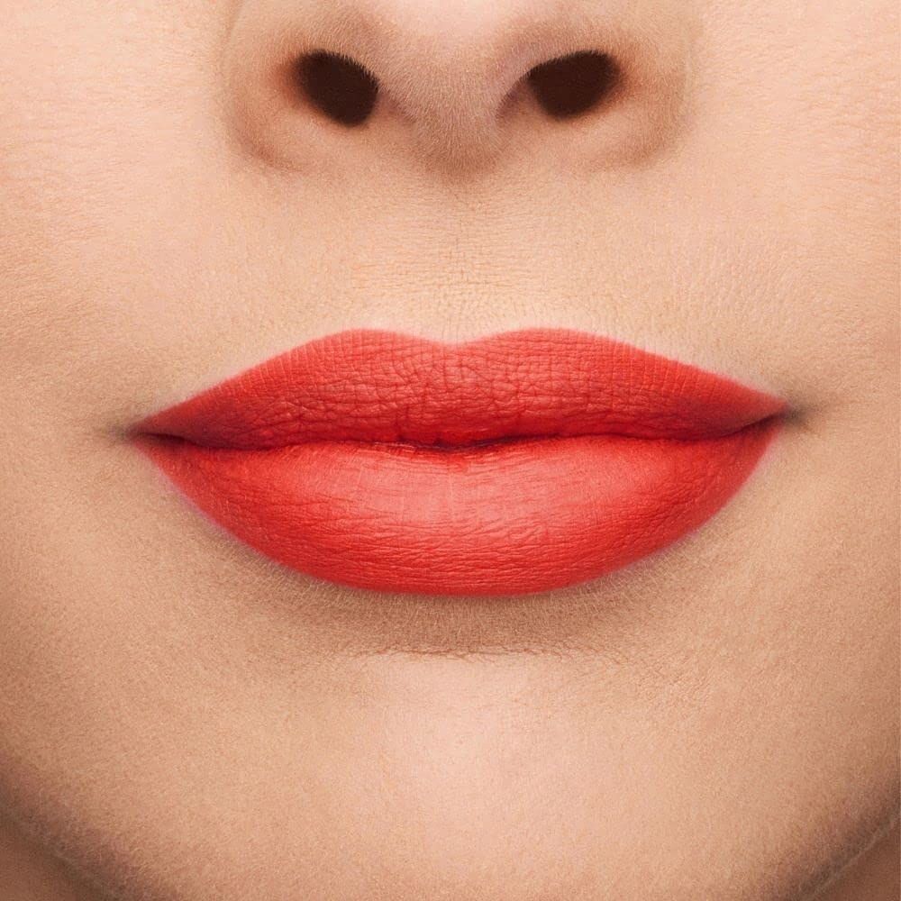 Primo piano di labbra coperte da rossetto rosso. Tono della pelle, naso visibile.