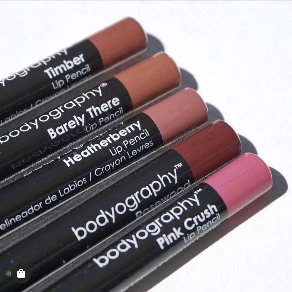 Cinque matite labbra affiancate. Fusti neri con nomi dei prodotti e marchio BODYOGRAPHY. Diverse tonalità.