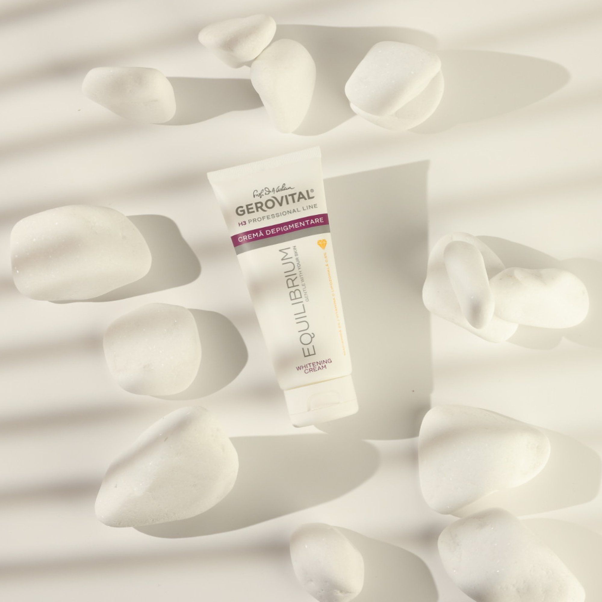 Tubo bianco circondato da pietre bianche. Scritta: Gerovital H3 Professional Line, Créma Depigmentare, Equilibrium Whitening Cream.