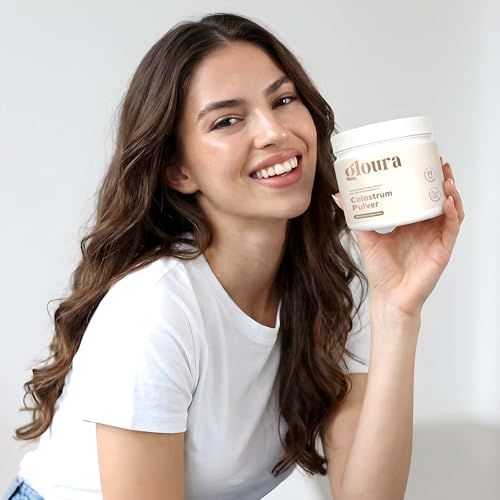 Donna che tiene un contenitore bianco con la scritta Gloura. Sorride alla fotocamera.