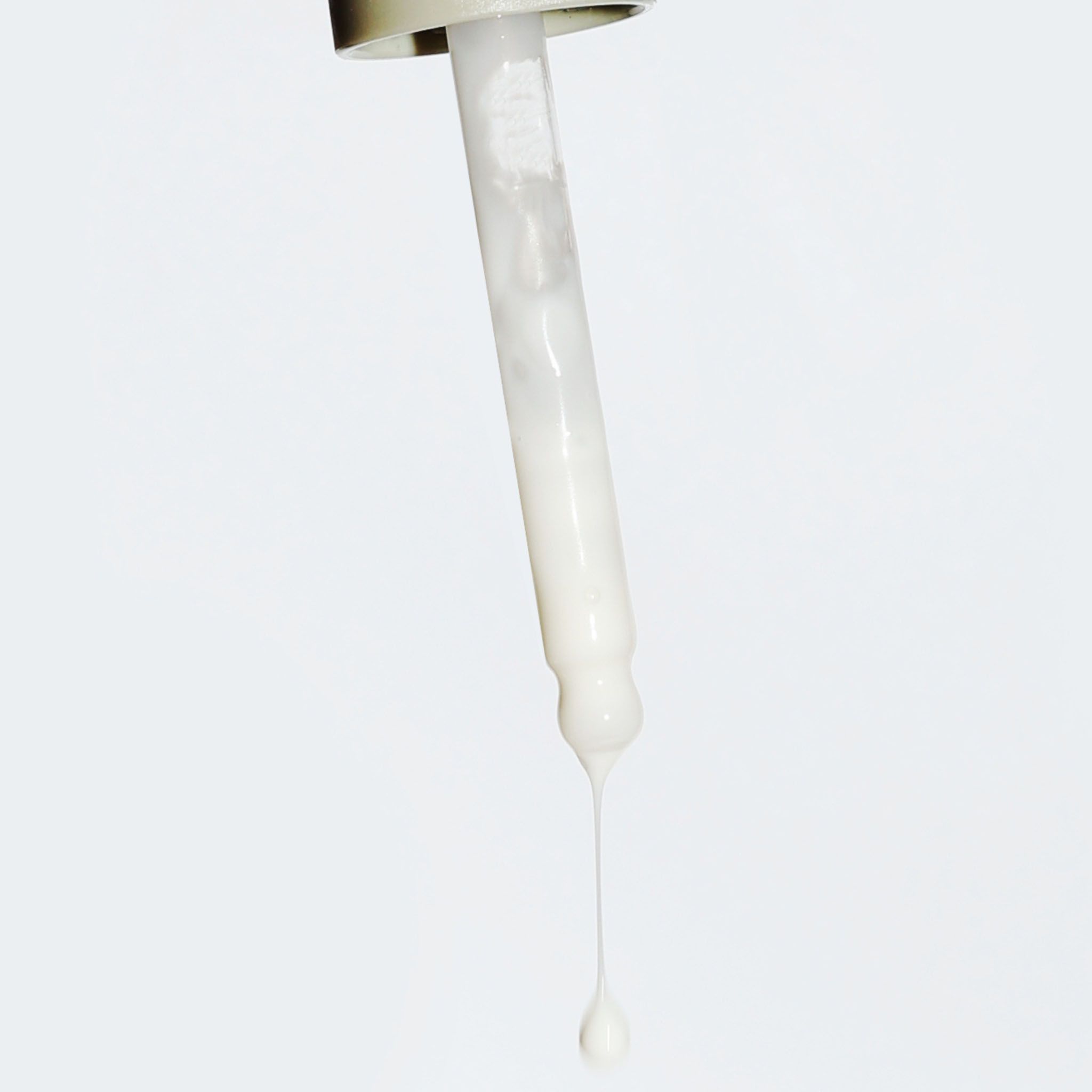 Contagocce con una goccia di siero bianco che pende dalla punta.