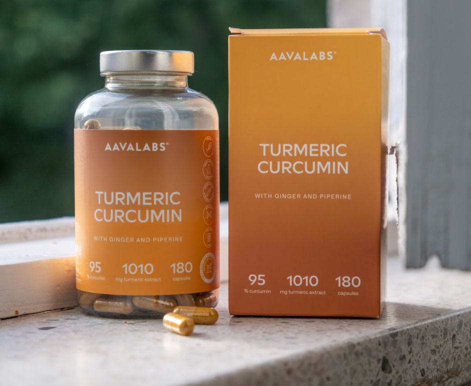 Flacone e scatola di capsule di curcuma su un davanzale esterno.