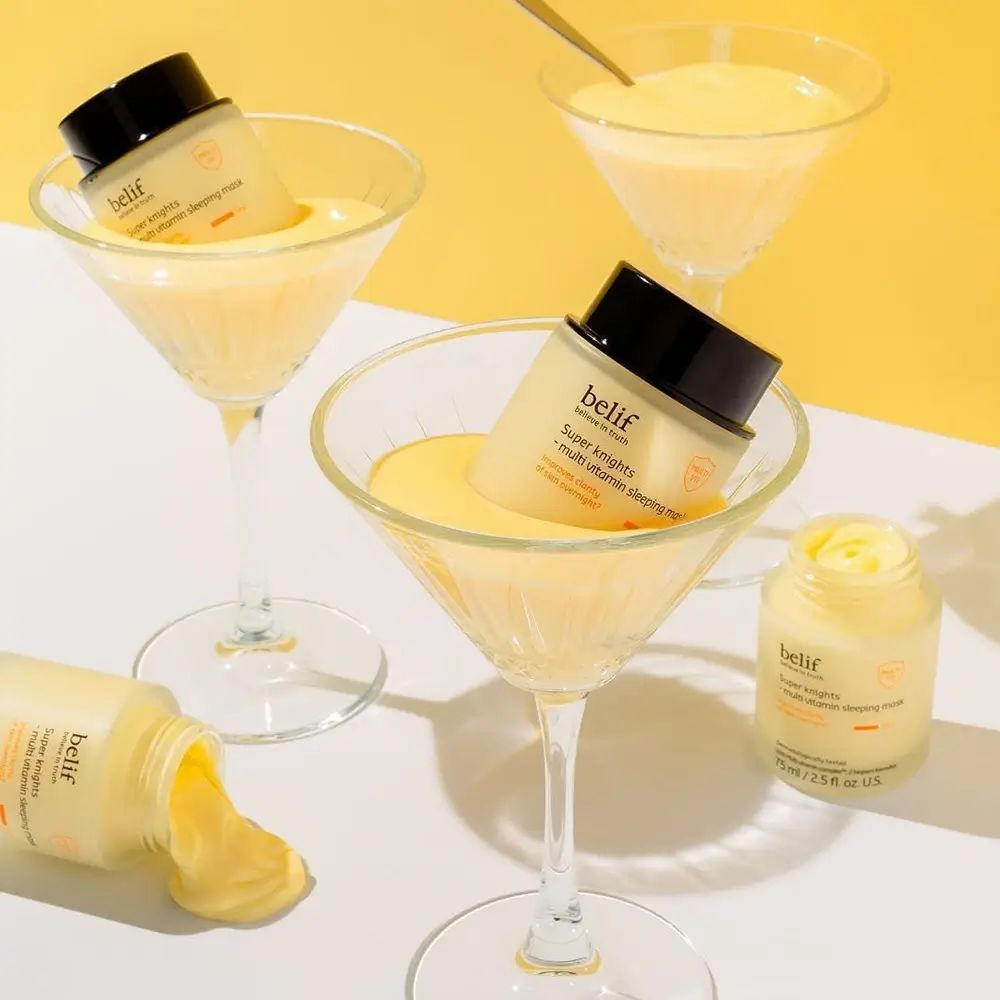 Diversi bicchieri con crema gialla e prodotto. Belif Super Knights Multi-Vitamin Mask. Crema gialla nei bicchieri e accanto. Coperchio nero.
