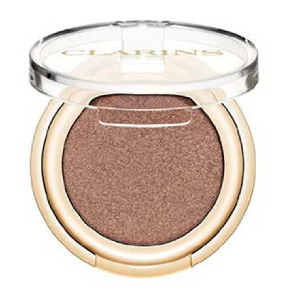 Ombretto Clarins rotondo, dorato. Coperchio aperto. Interno: Satin Taupe. Scritta Clarins.