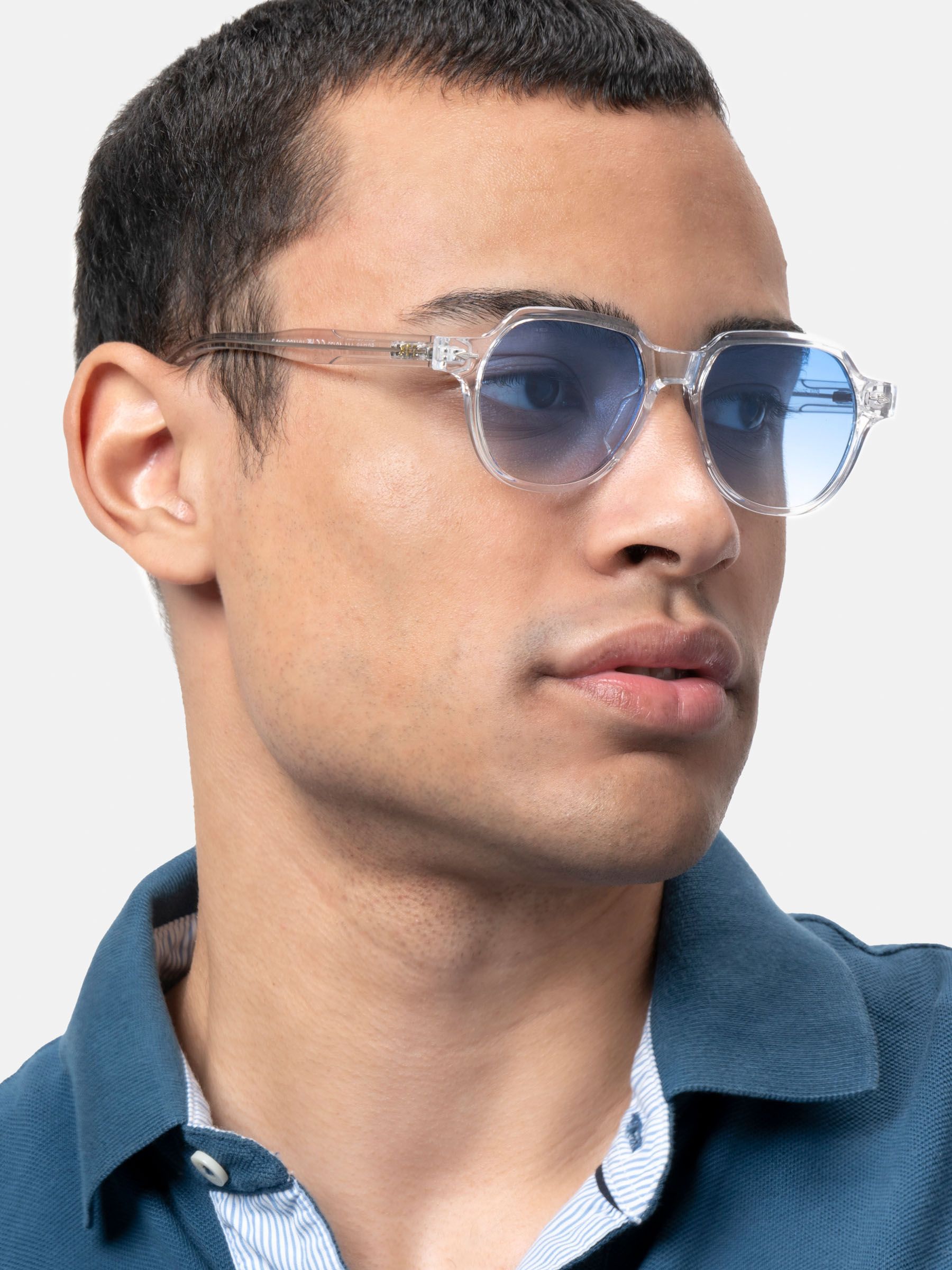 Un uomo indossa occhiali da sole con montatura trasparente e lenti blu. Primo piano.
