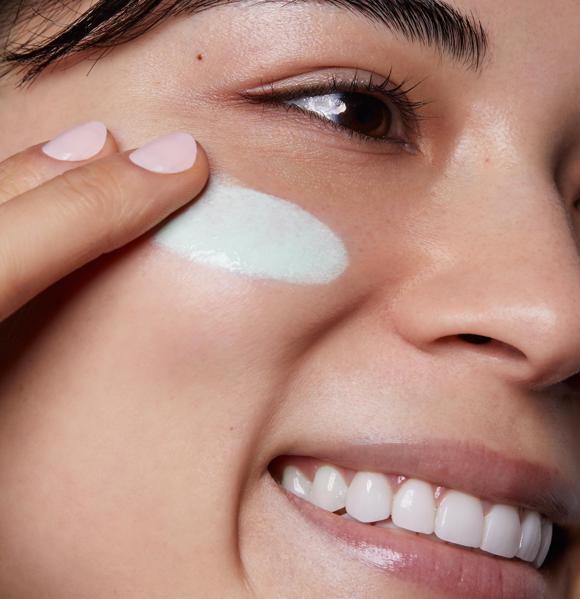 Donna applica prodotto verde. Viso, primo piano.