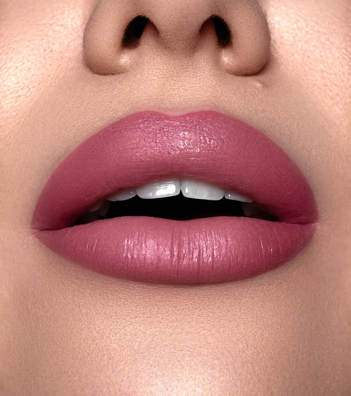 Primo piano di labbra con rossetto rosa opaco.