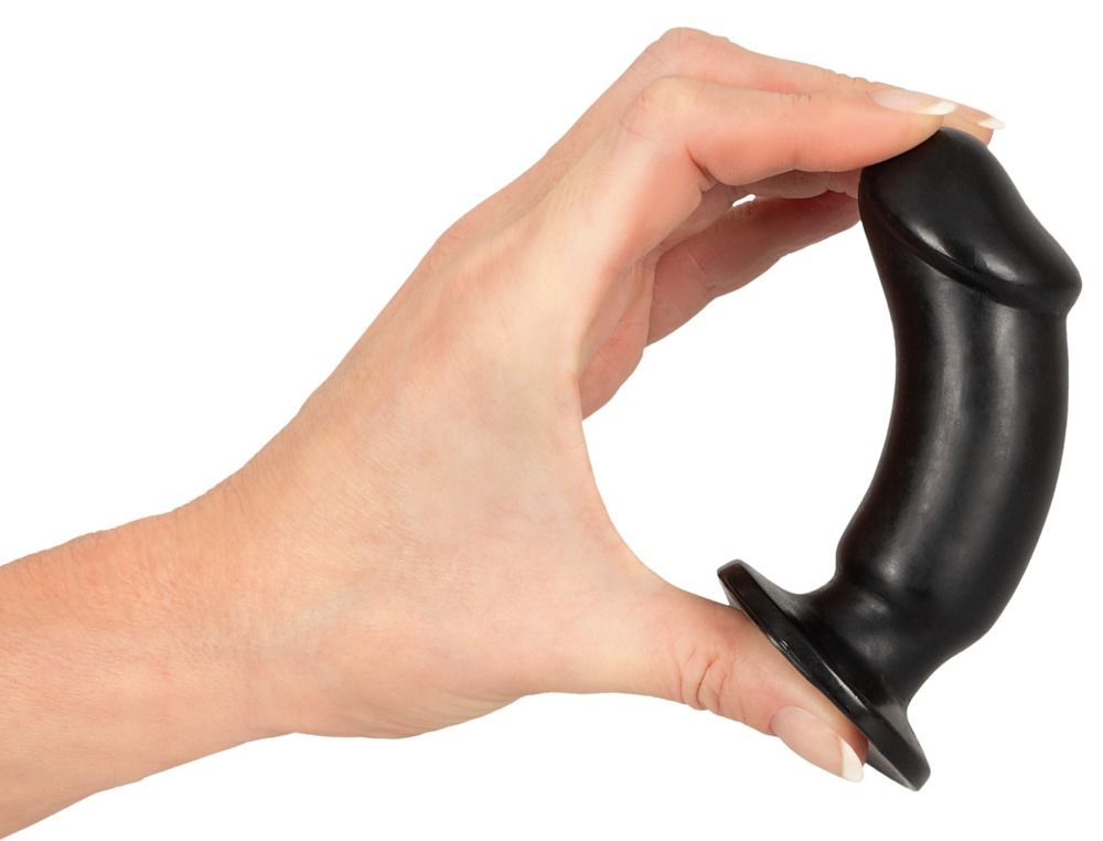 Una mano tiene un plug anale nero. La forma è cilindrica con una punta arrotondata e un'ampia base.
