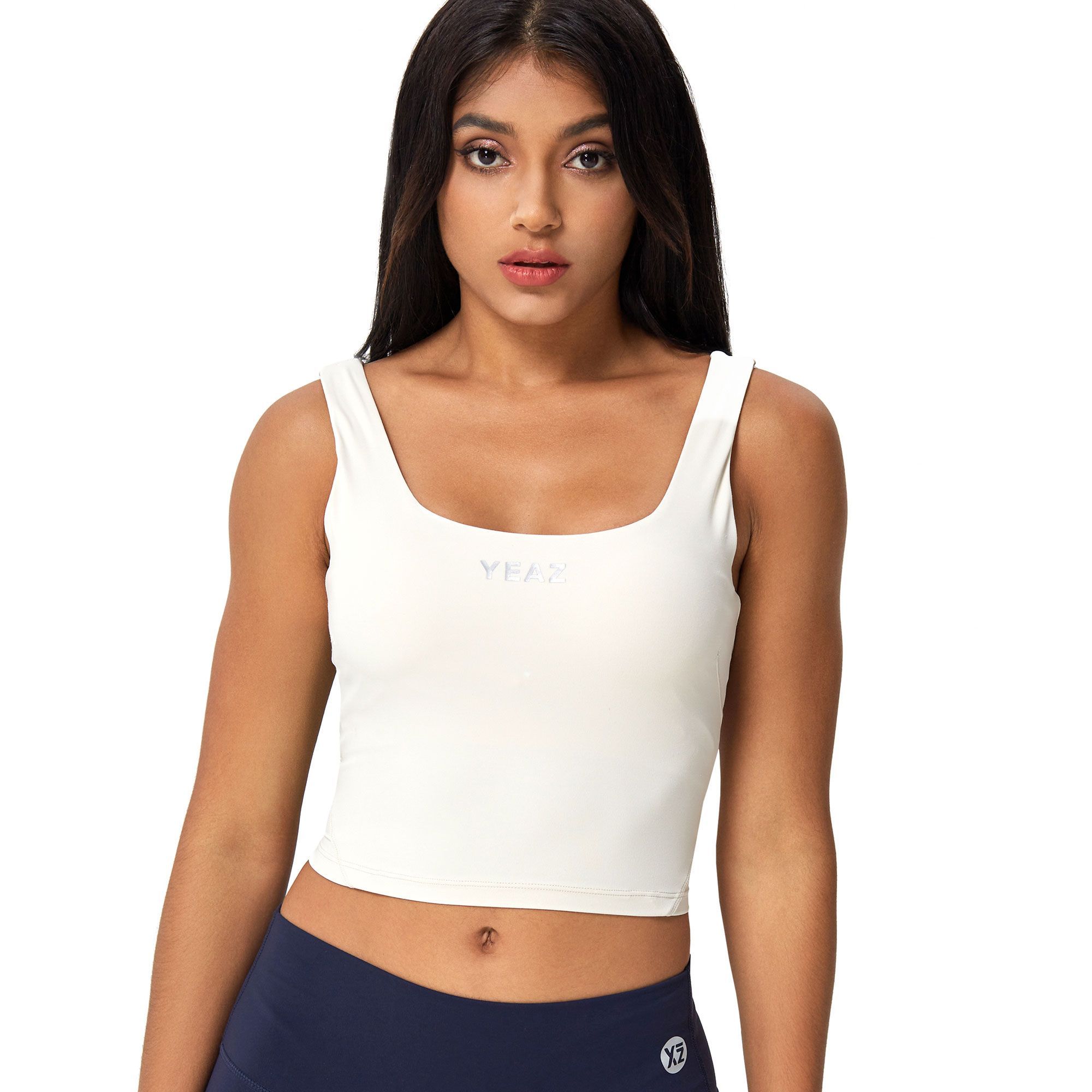 Crop top senza maniche color crema con scollo quadrato e logo discreto.