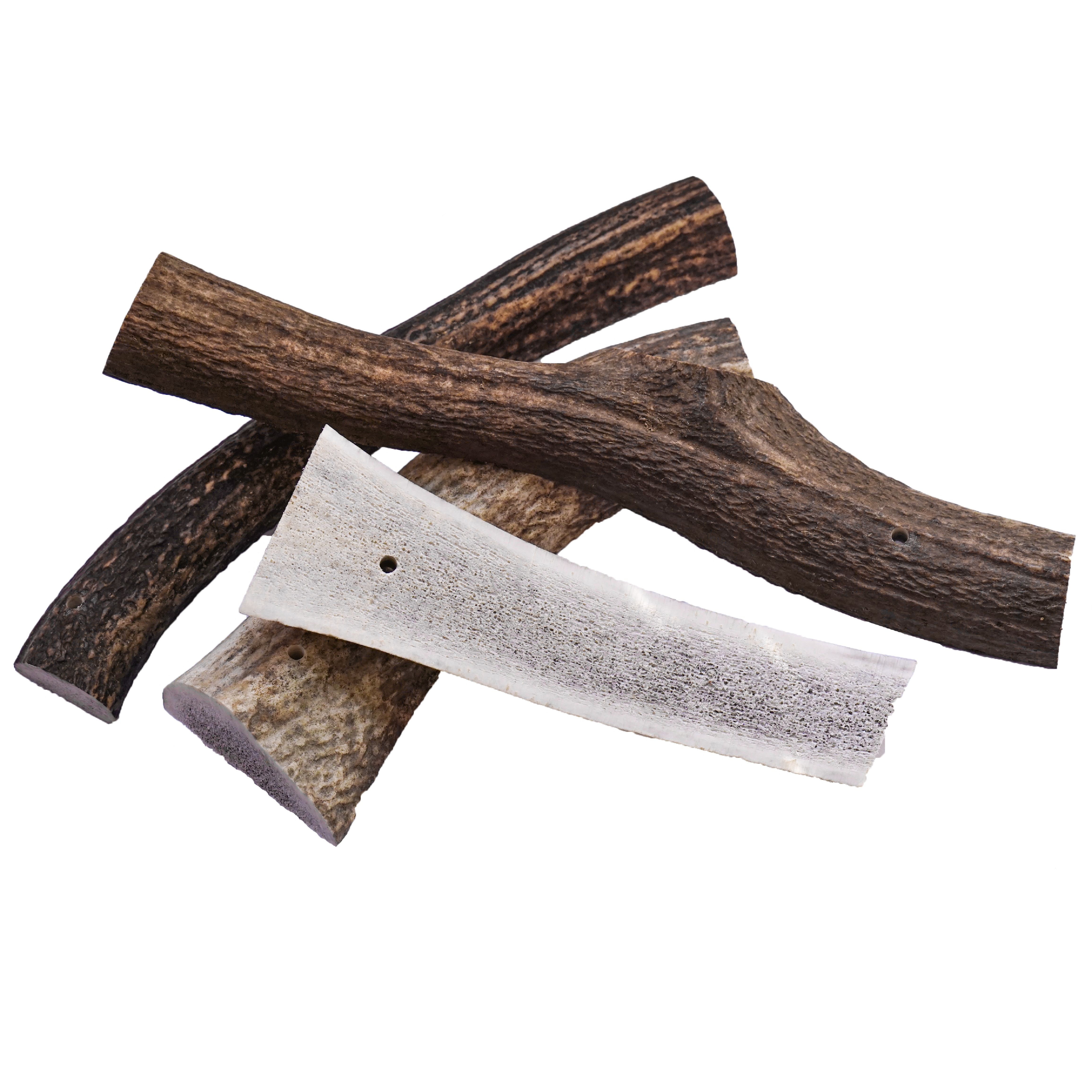 Pezzi di corna di cervo dimezzati. Diversi pezzi in varie tonalità di marrone. Alcuni pezzi sono allungati, altri hanno una forma irregolare.