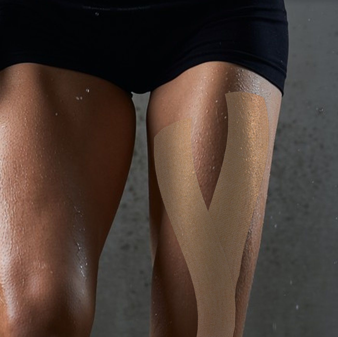 Gamba con kinesio tape. Nastro marrone sulla coscia. Primo piano.