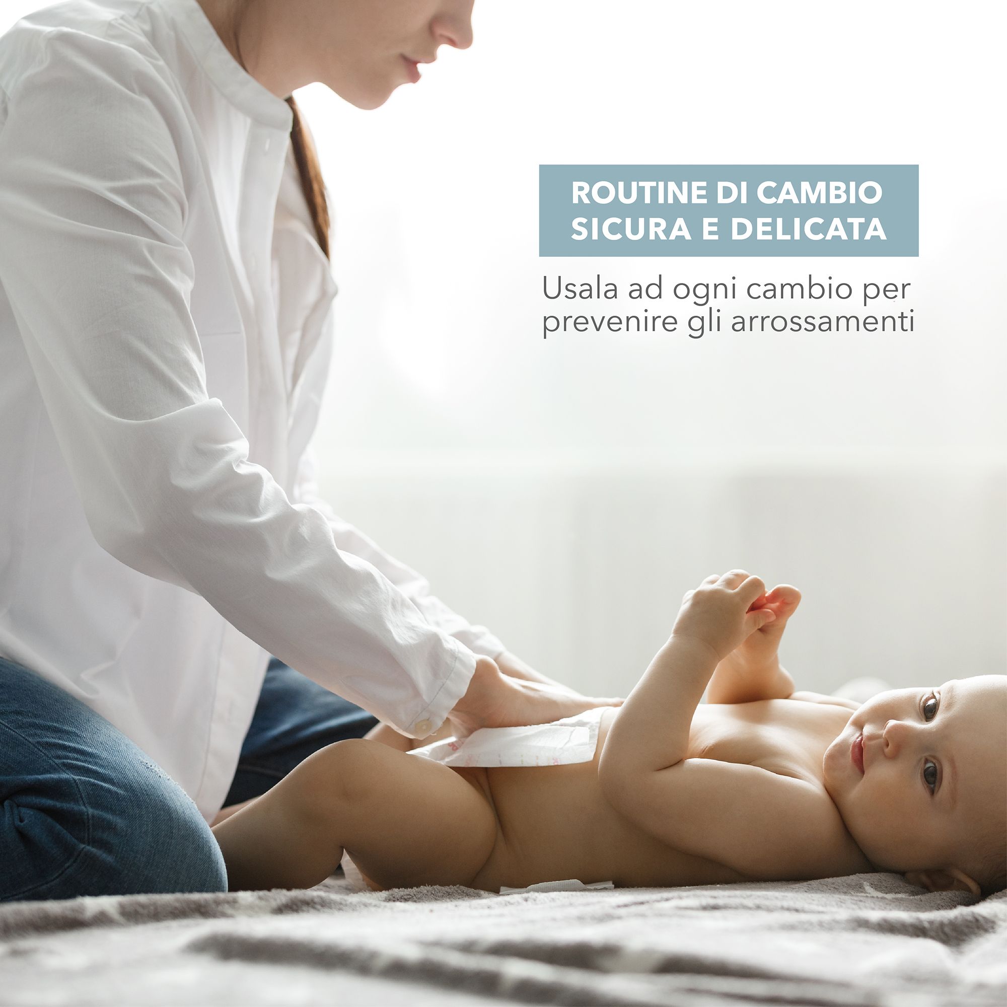 Una persona cambia un bambino. Testo: Routine sicura e delicata. Usare ad ogni cambio per prevenire gli arrossamenti.