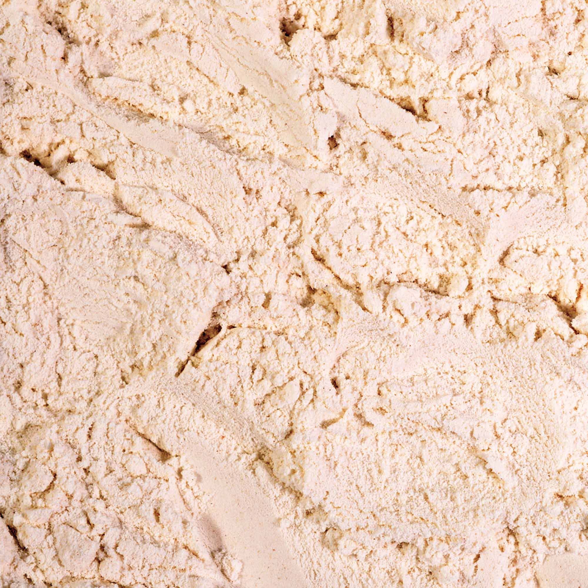 Polvere fine color beige chiaro con texture irregolare e leggeri grumi.
