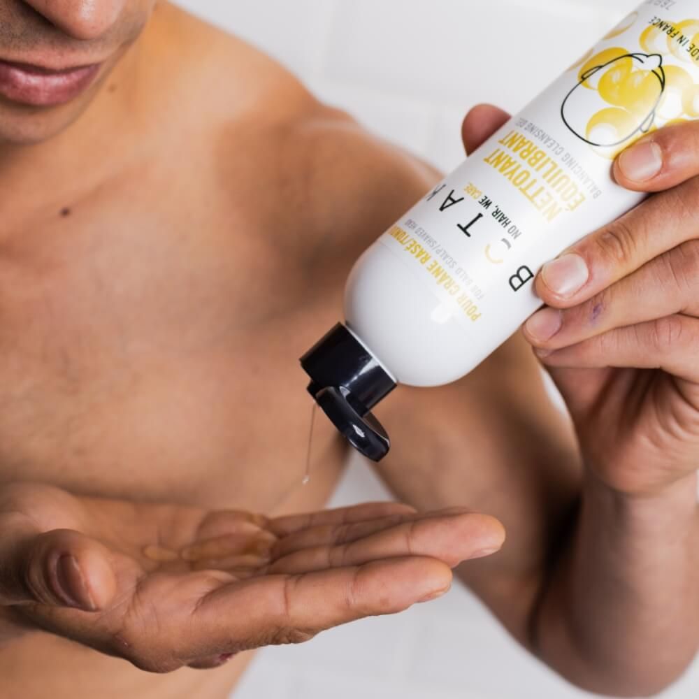 Uomo versa liquido da una bottiglia nella sua mano. Bottiglia con scritta BOTAK.