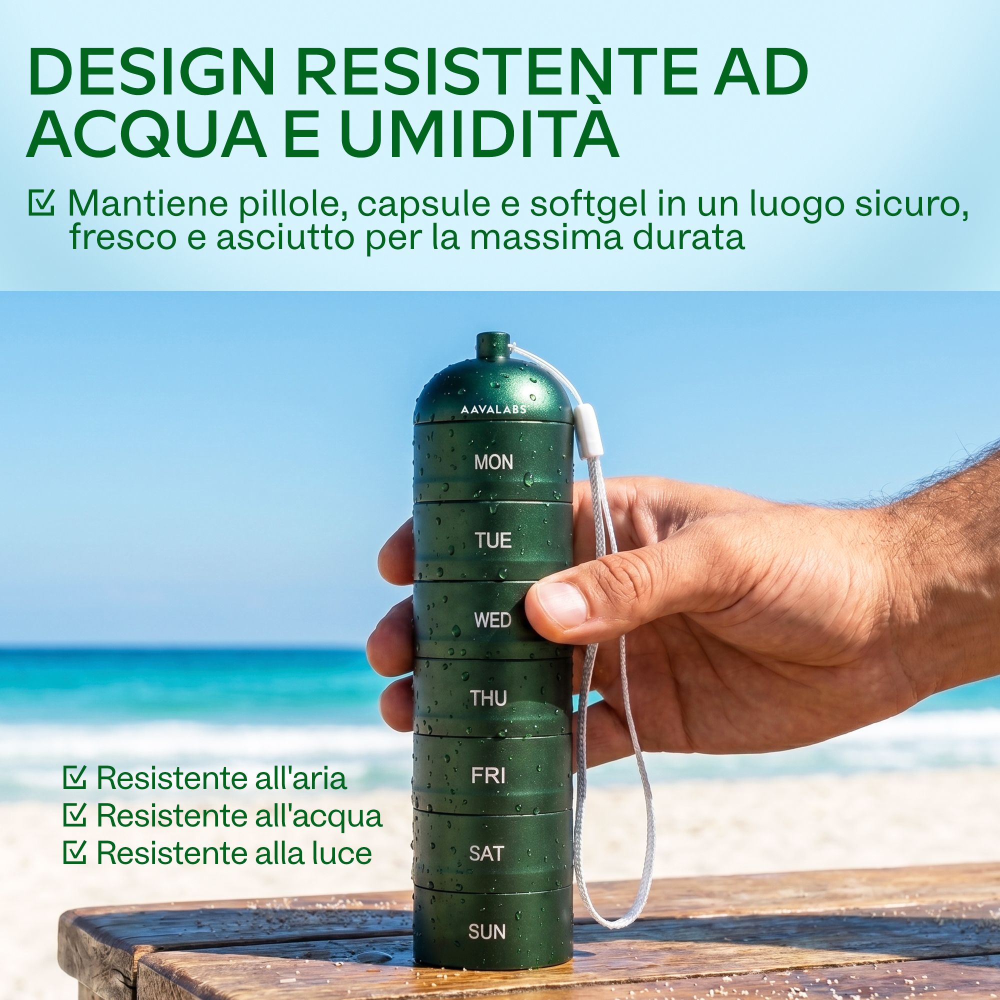 Portapillole verde a 7 scomparti, impermeabile, tenuto da una mano sulla spiaggia.