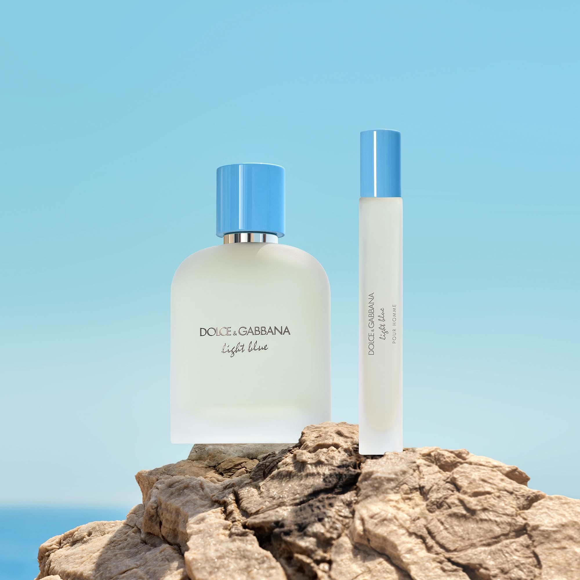 Flacone di profumo e piccolo vaporizzatore su una roccia. Scritta: Dolce & Gabbana Light Blue. Tappo azzurro chiaro.