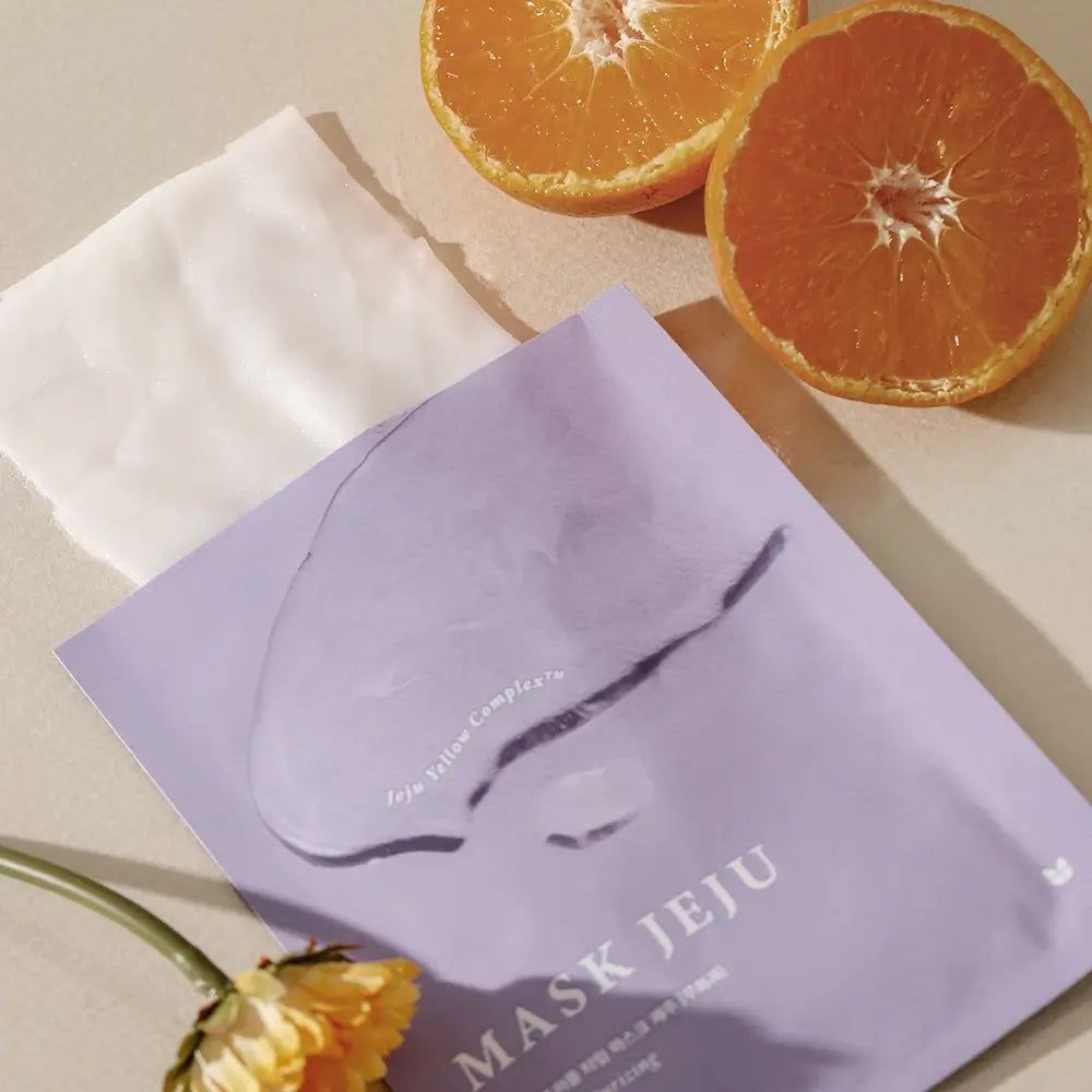 Maschera MIZON Jeju viola, maschera bianca e arance. Scritta: MASK JEJU. Con Jeju Yellow Complex.
