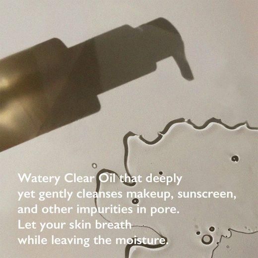 Olio su una superficie. Testo: Watery Clear Oil, pulisce trucco, protezione solare. Lascia respirare la pelle e idrata.